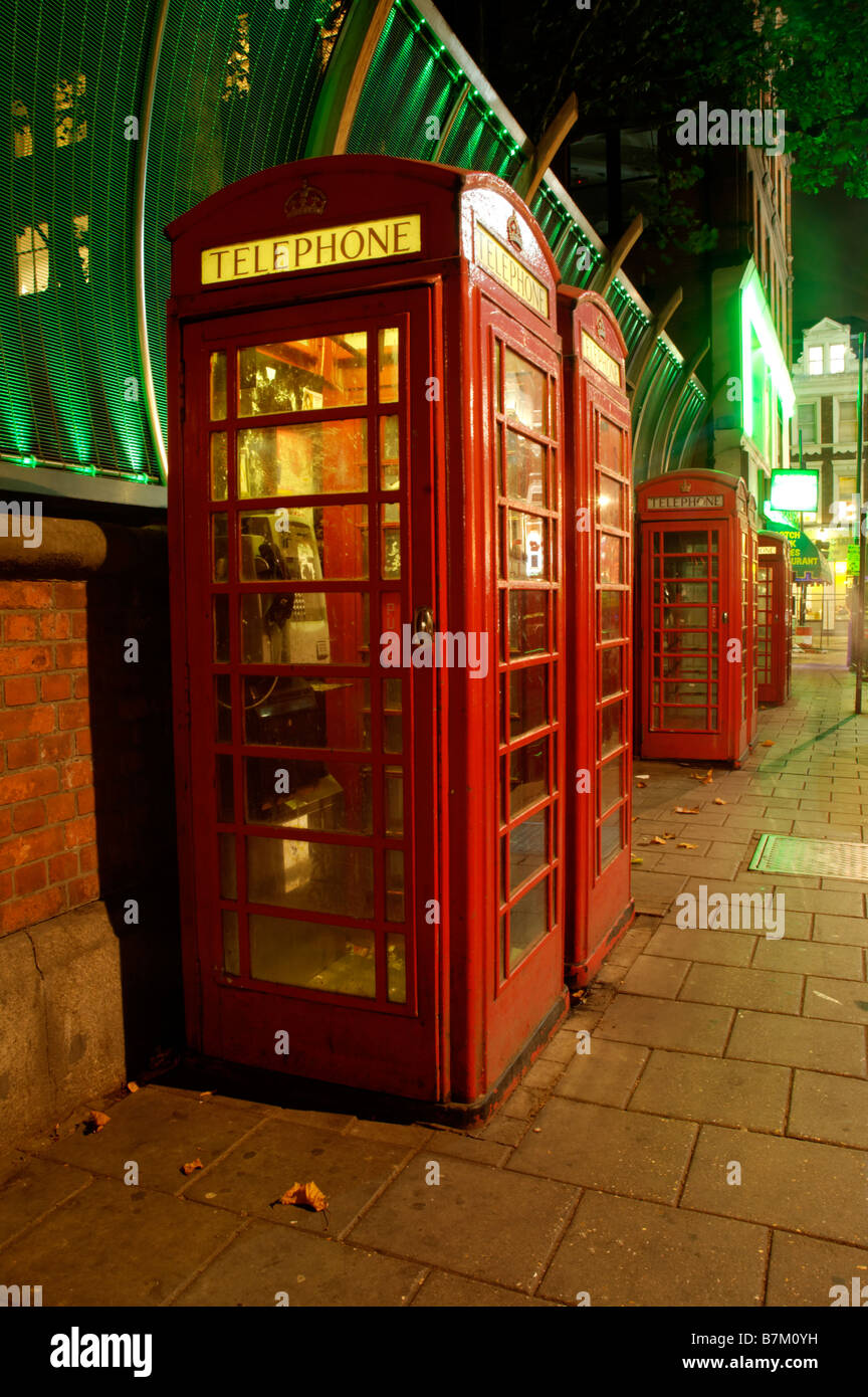 A row of red telephone booths in London at night Stock Photo