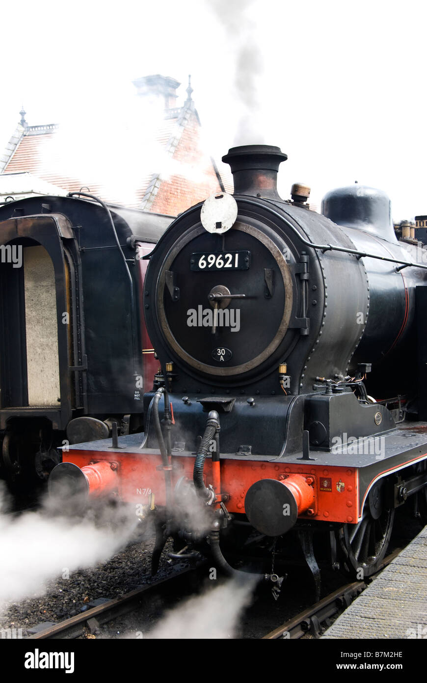 Steam engine 69621 lets off steam at Weybourne station on the North Norfolk Railway. Norfolk, England, UK. Stock Photo