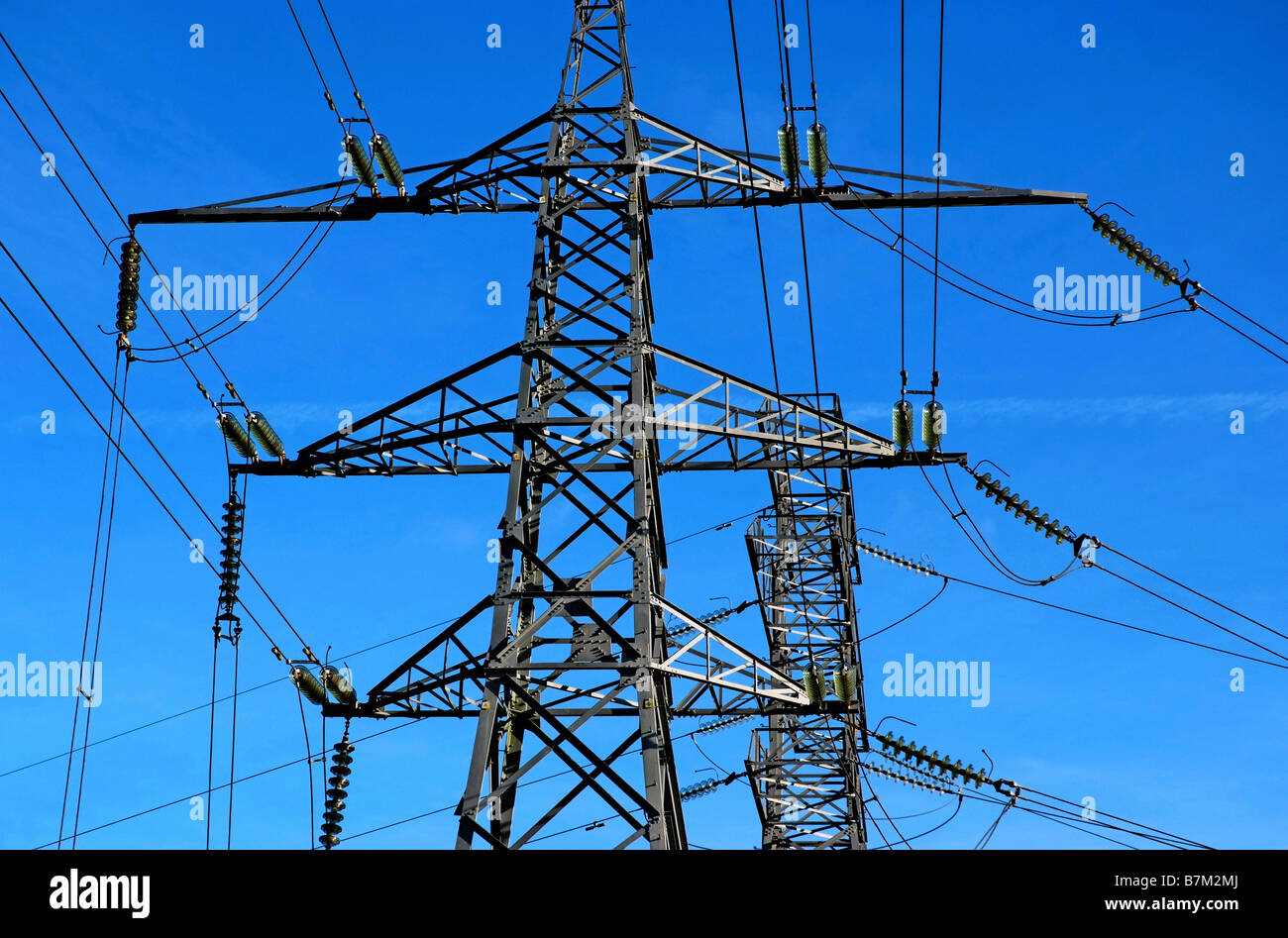Two electricity pylons with a blue sky background Stock Photo - Alamy
