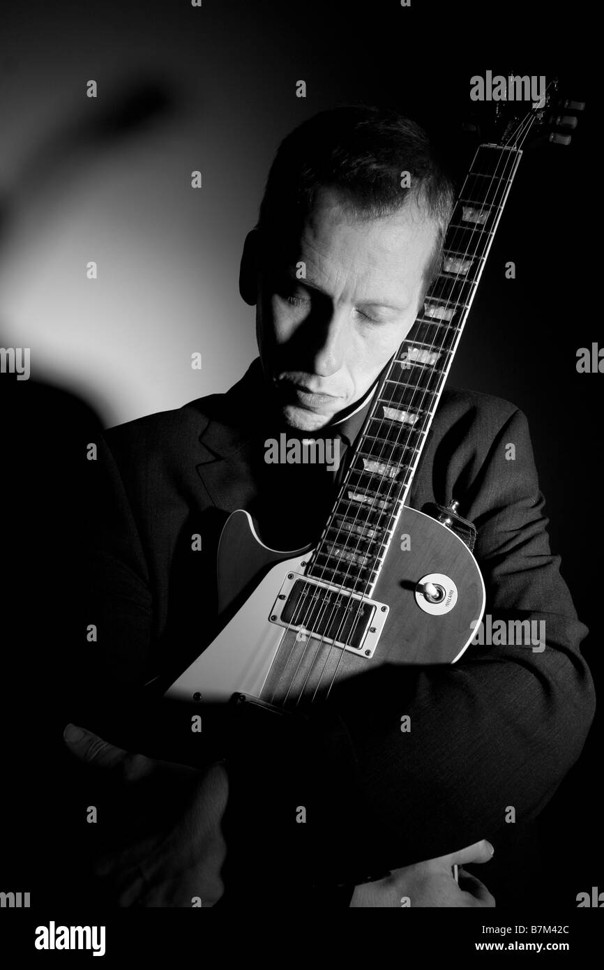 guitar player cradling instrument Stock Photo