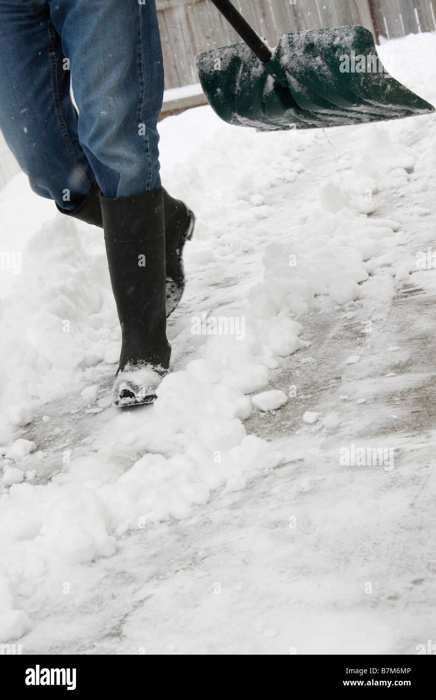 Man shoveling snow from the sidewalk in winter hi-res Stock Photo