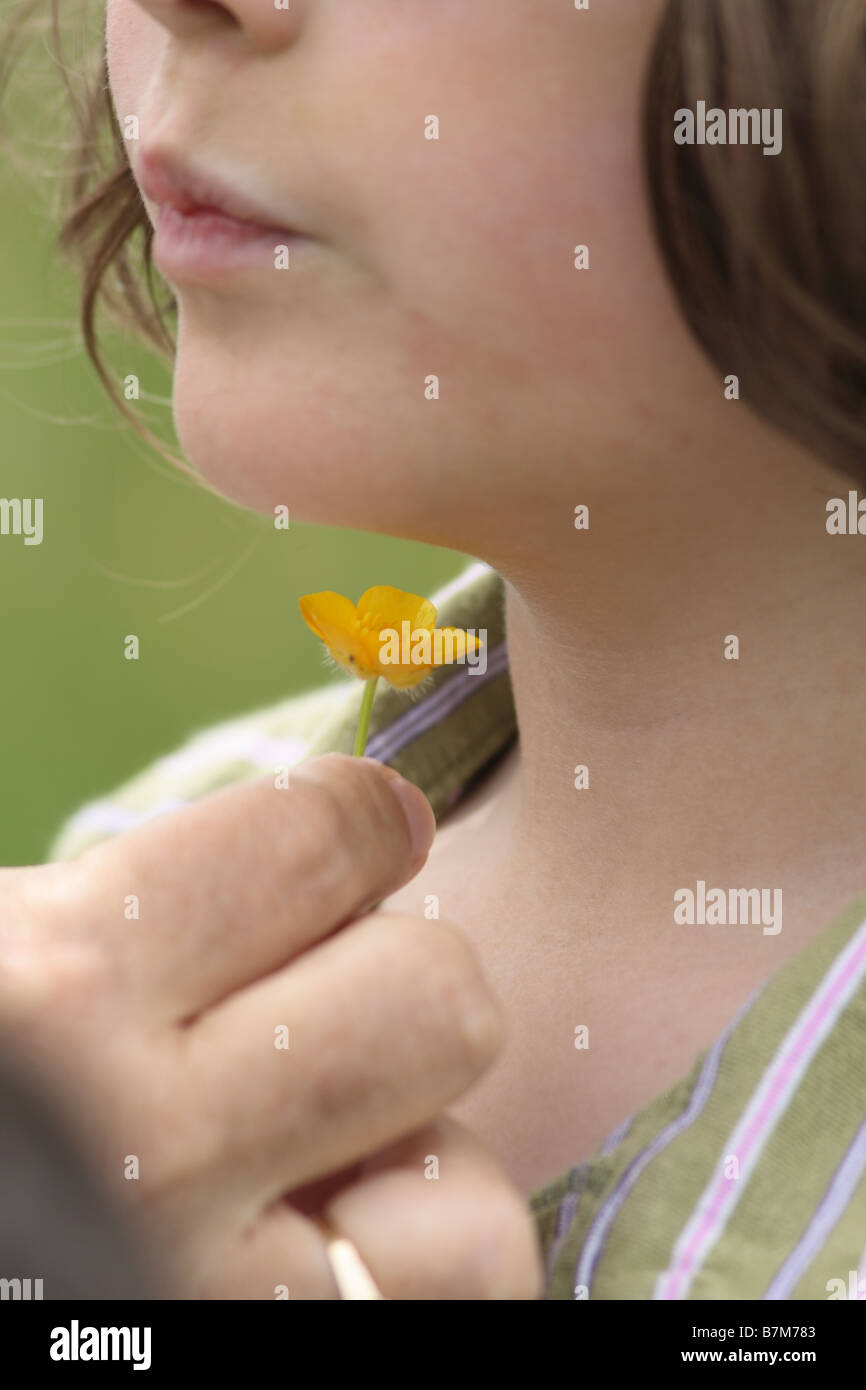 checking to see if the child likes butter by holding a buttercup under