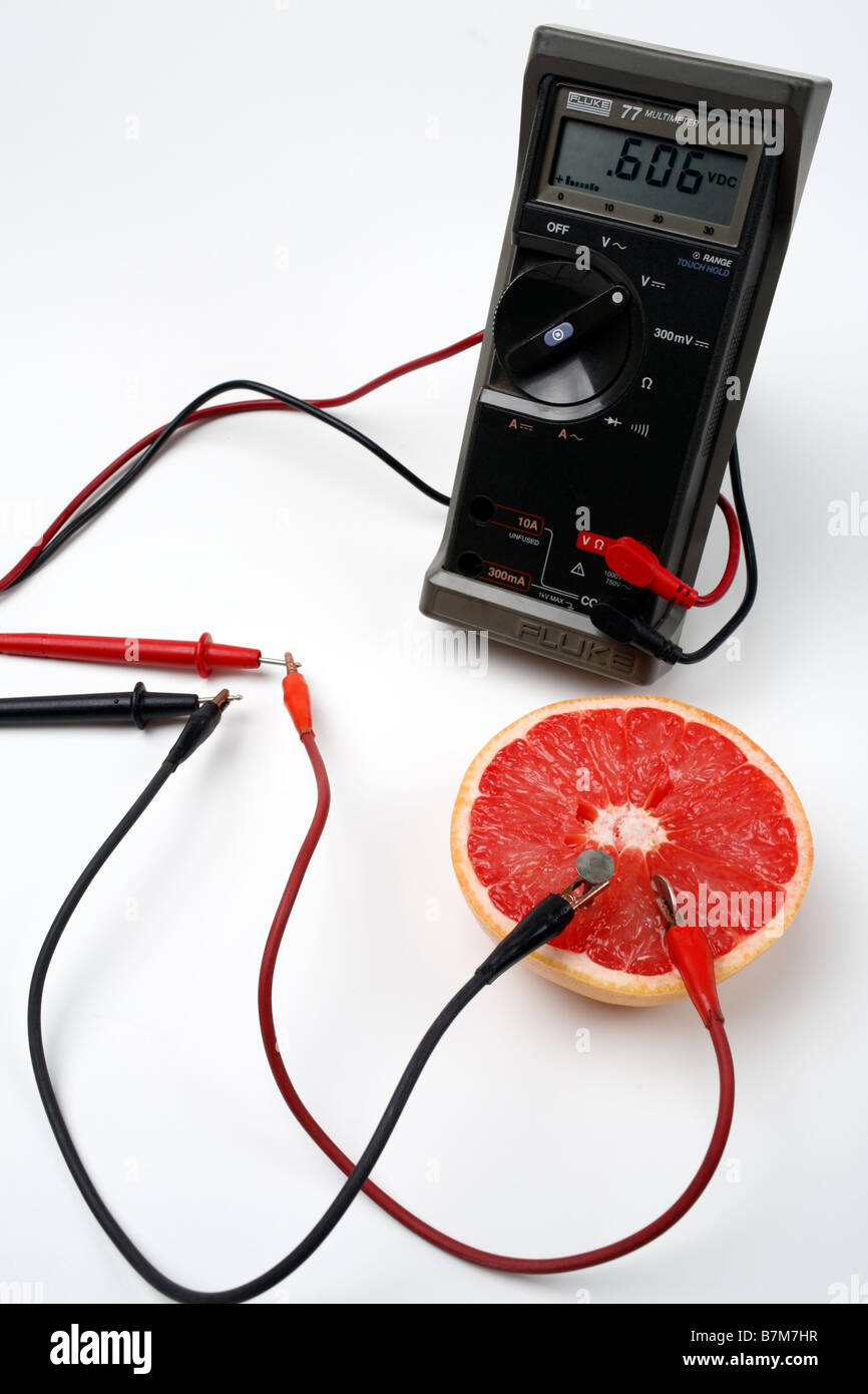 Grapefruit battery with multimeter nail dime alligator clip leads Stock Photo