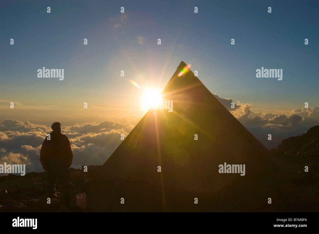 Kilimanjaro Climber watching the sunset from his tent on the Western Breach Tanzania Stock Photo