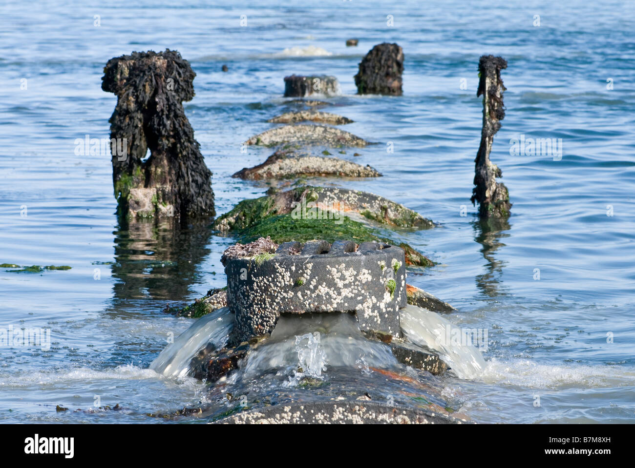 Raw sewage being discharged into shallow sea from the vent in a sewage outfall pipe. Stock Photo