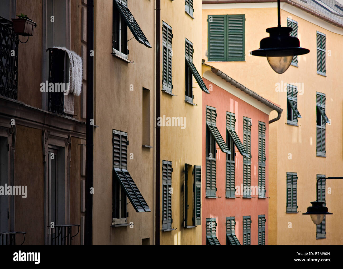 A Genoa side street showing street lights and colourful apartments with