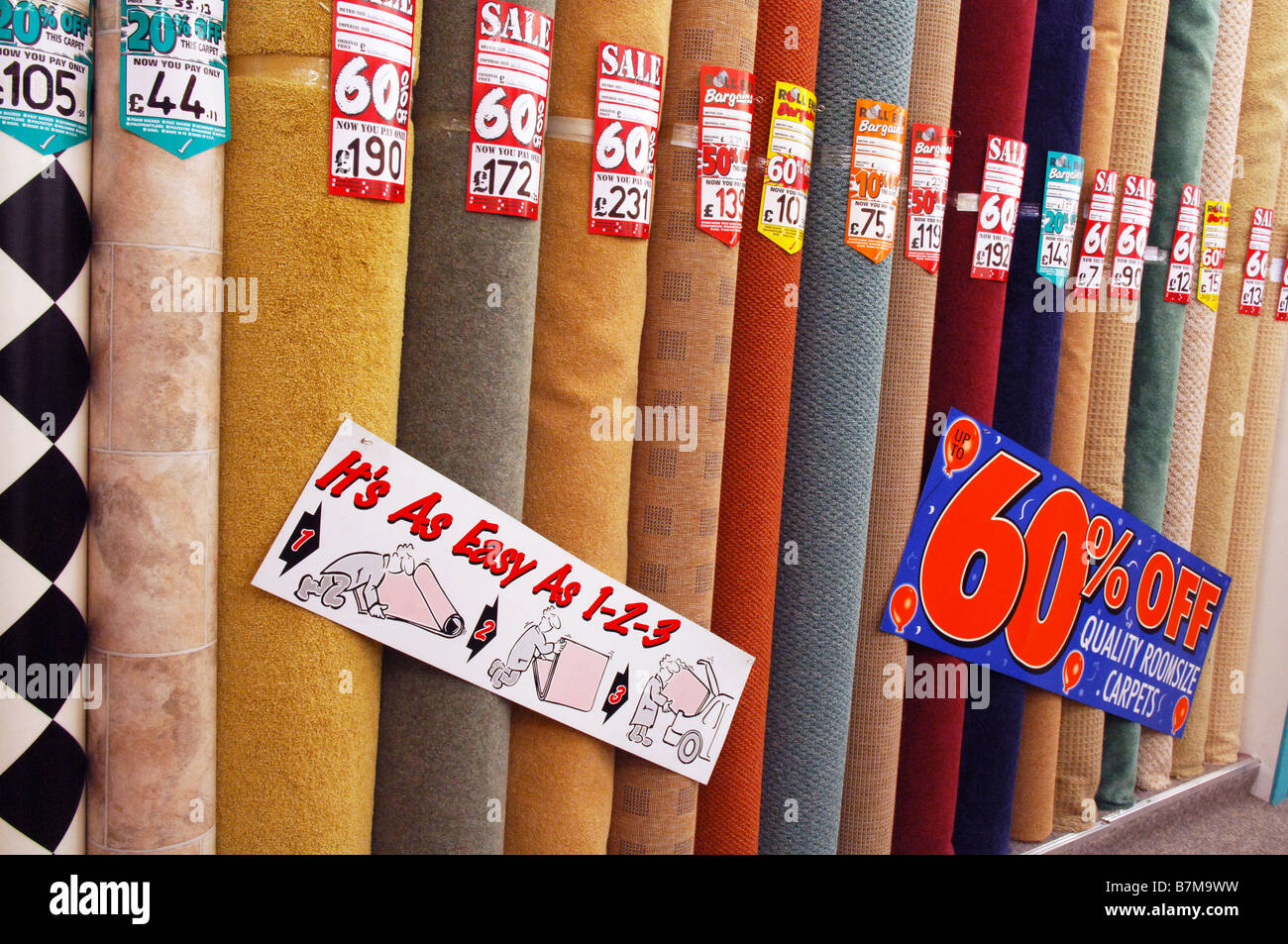Rolls of different discount carpets for sale in Carpet Right, some with up  to 60% off with the sign "It's as easy as 1-2-3 Stock Photo - Alamy