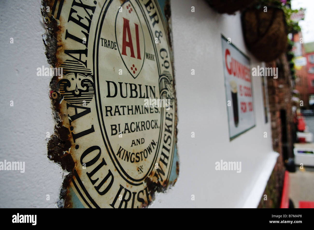 Old, weathered sign advertising Guinness on the wall of the Duke of York pub, Belfast. Stock Photo