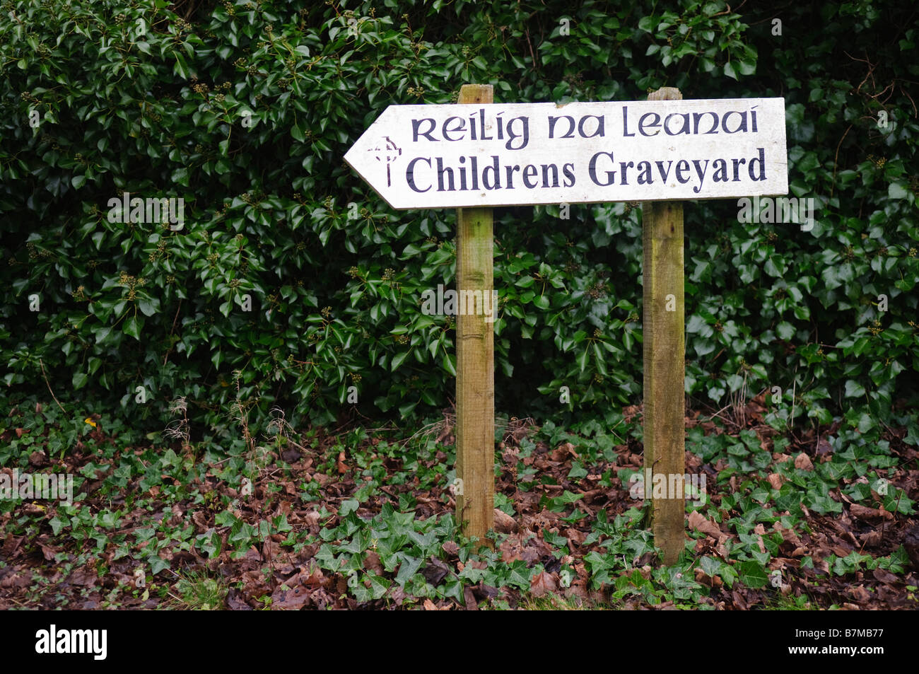 Direction sign to an Children's Graveyard in Ireland, in English and Irish Gaelic Stock Photo
