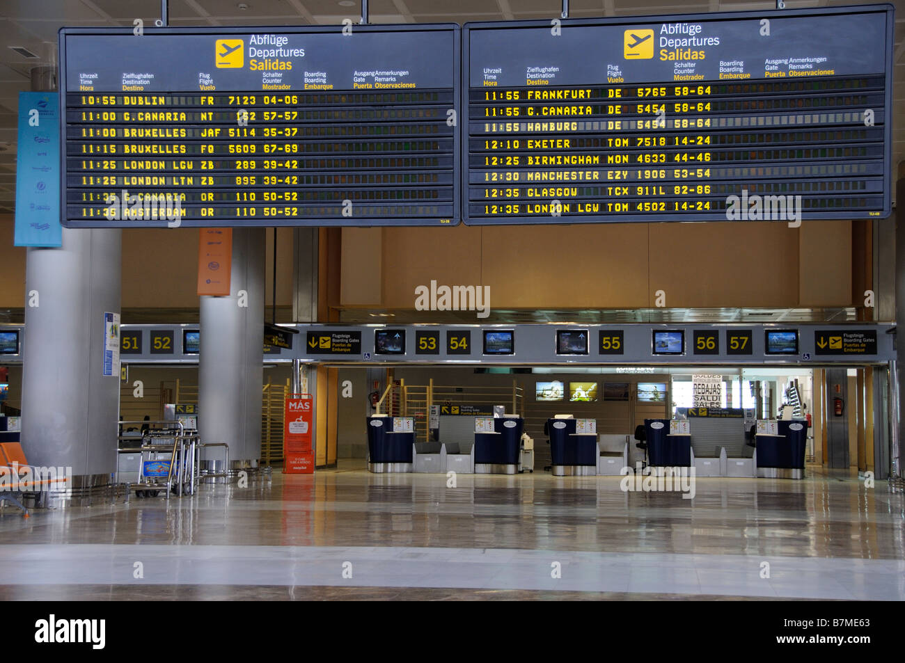 Airport terminal airline arrival and departures board travellers Reina Sofia Airport in southern Tenerife Canary Islands Stock Photo