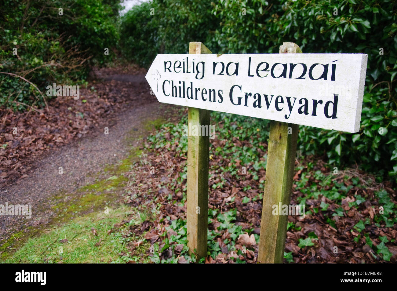 Direction sign to an Children's Graveyard in Ireland, in English and Irish Gaelic Stock Photo