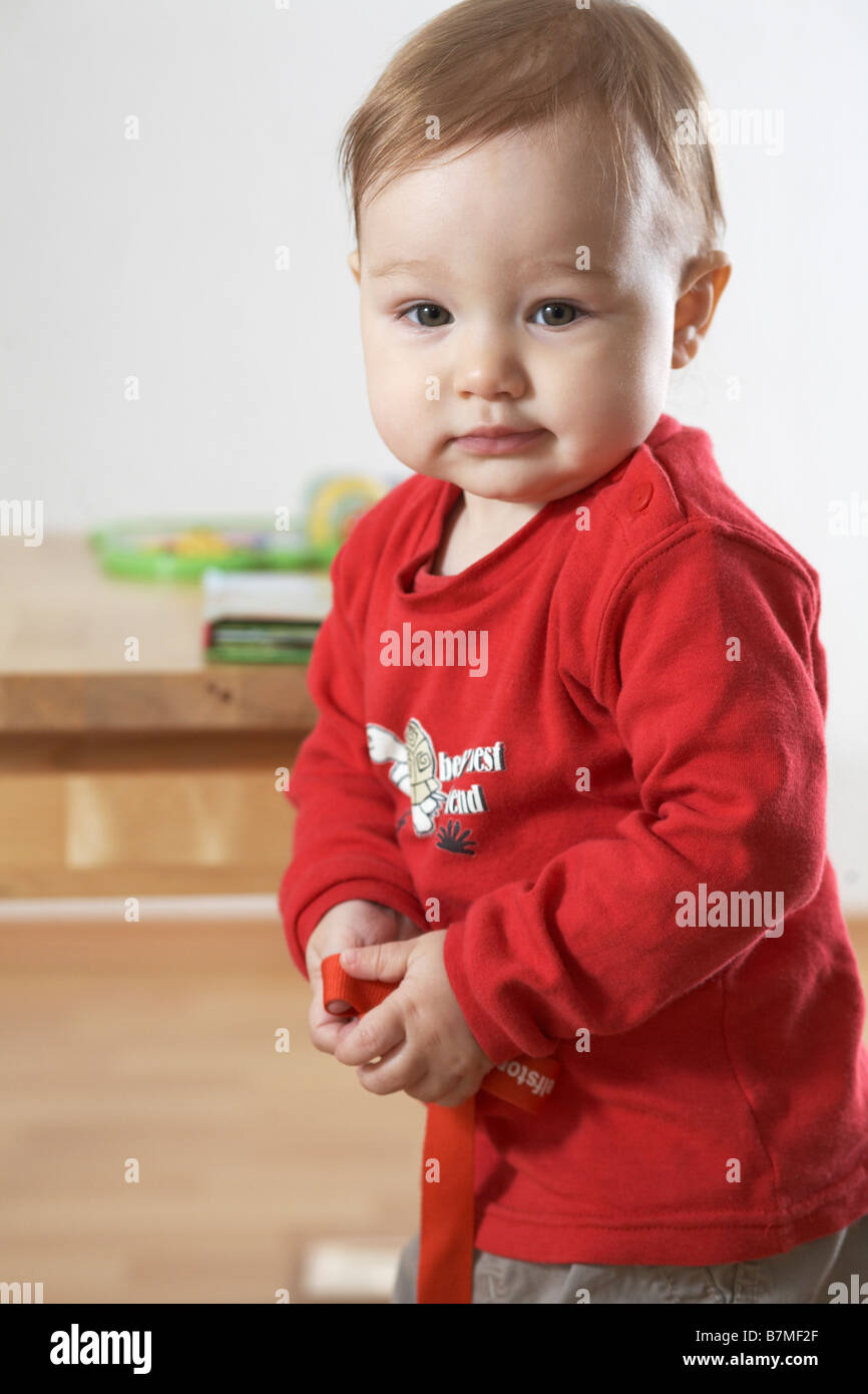 Child (12-18 month) holding toys, looking at the camera. Stock Photo