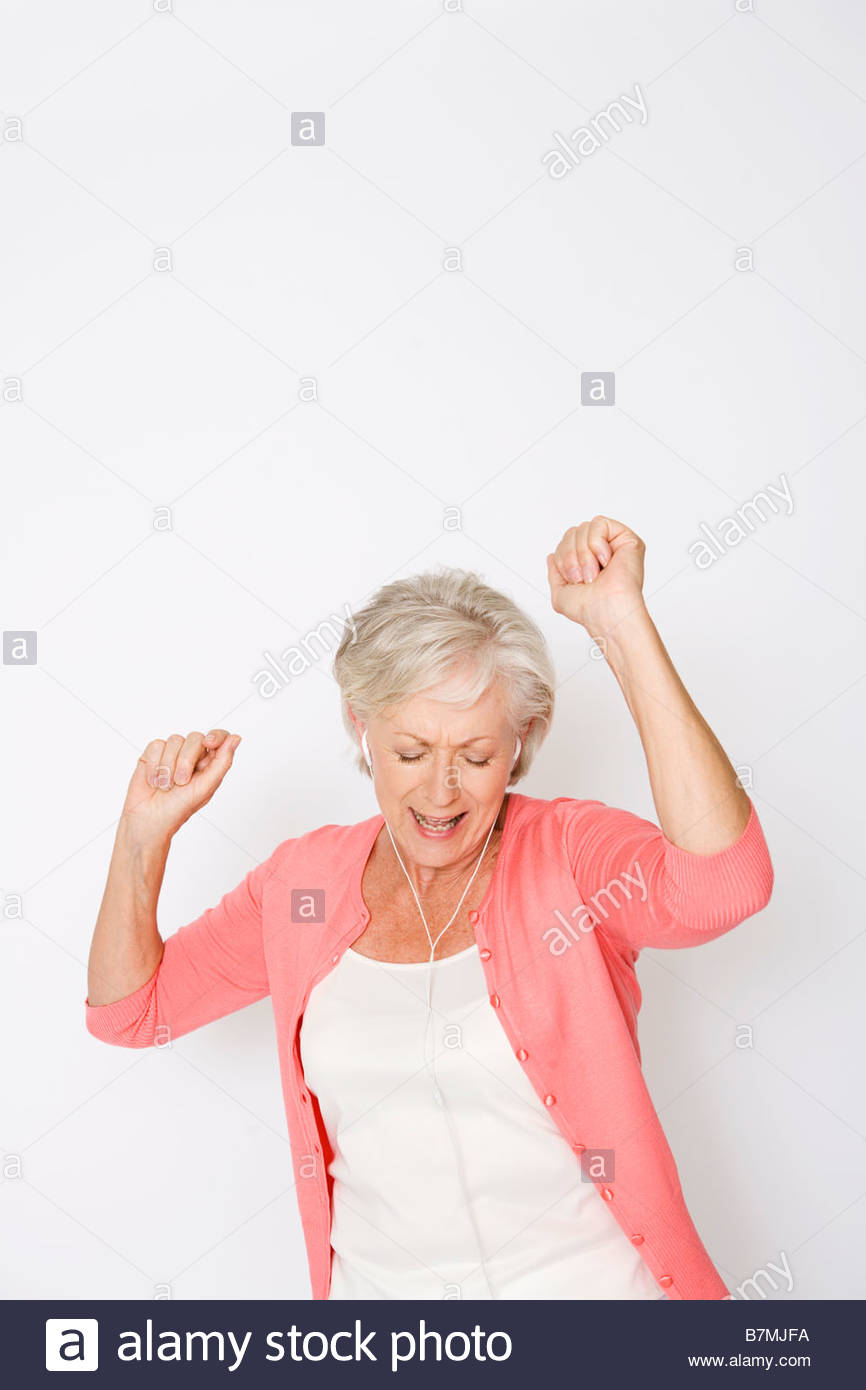 A Senior Woman Dancing To Music On An Mp3 Player Stock Photo