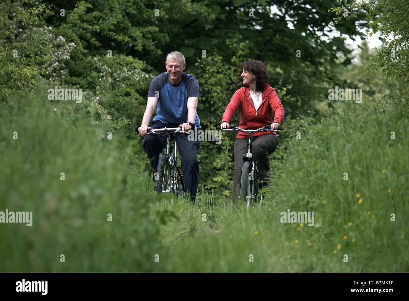 Couple cycling on the disused railway line near Market Weighton The Wolds East Yorkshire UK Stock Photo
