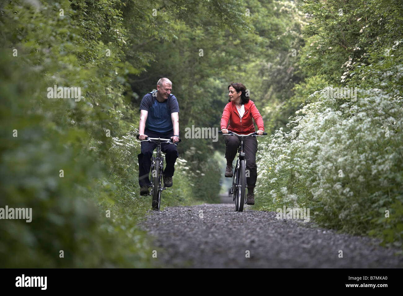 Couple cycling on the disused railway line near Market Weighton The Wolds East Yorkshire UK Stock Photo