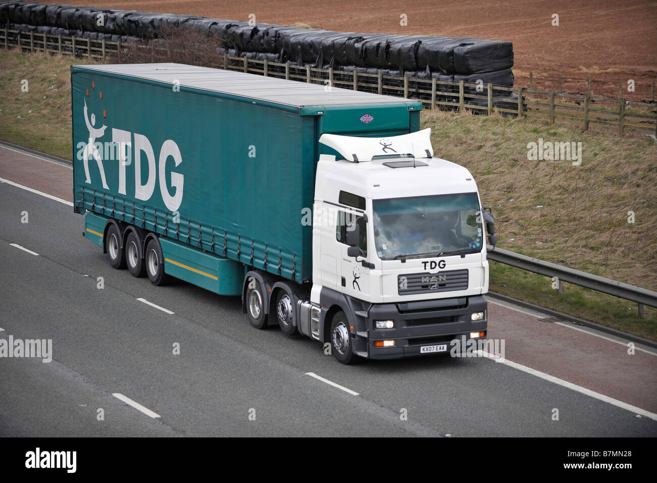 Three axle MAN TGA truck with curtainsided tri axle trailer TDG Transport Development Group on M6 Motorway Stock Photo
