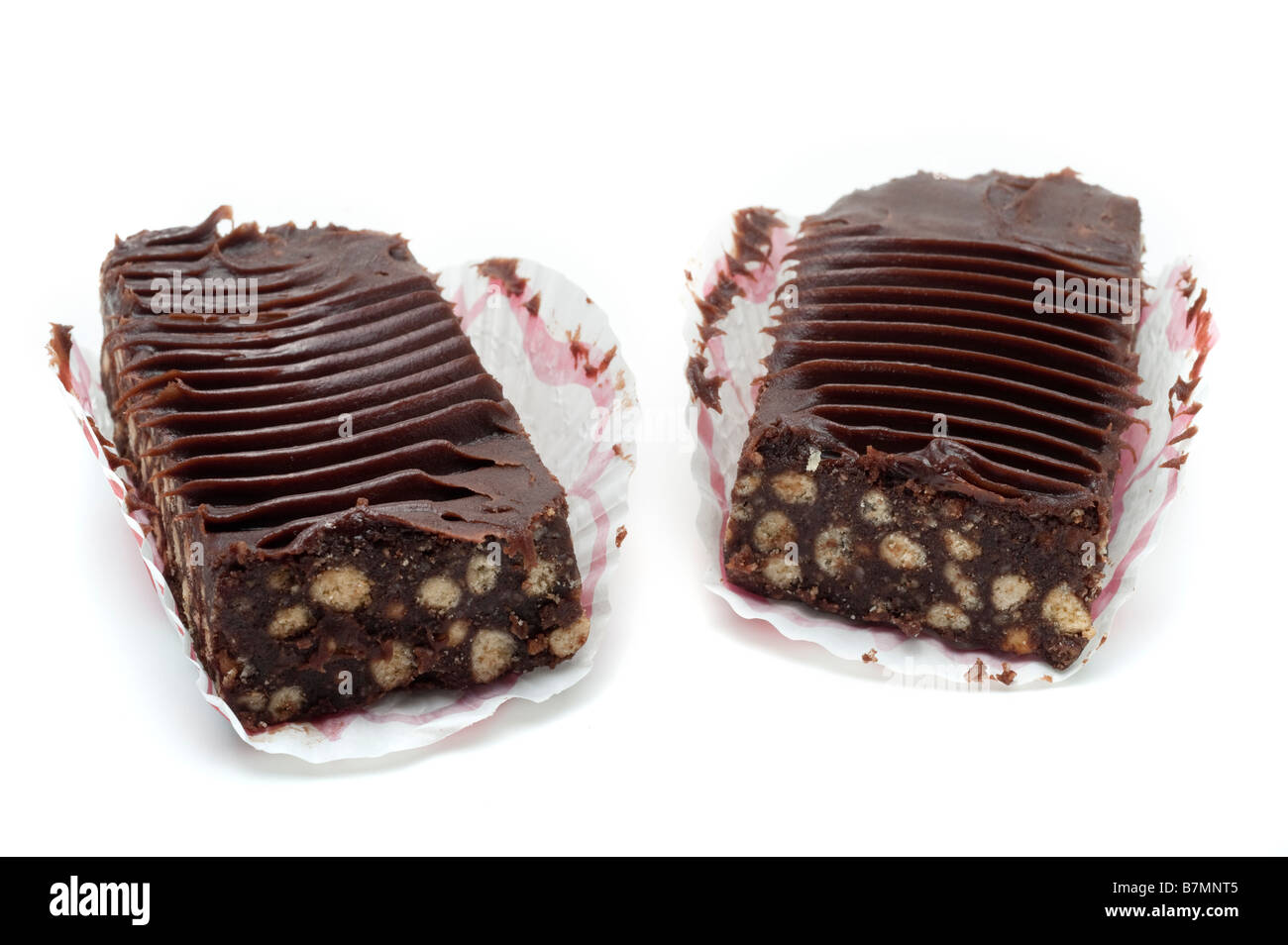 Two 2 chocolate slices with biscuit in paper cases Stock Photo