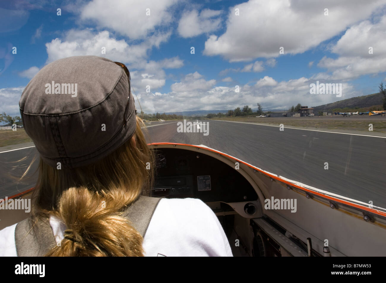 Female pilot landing glider airplane on runway at Dillingham Airfield in Oahu Hawaii Stock Photo