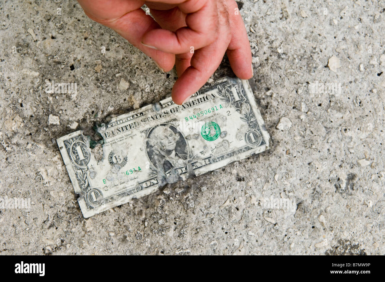 dollar bill stuck to the sidewalk usa default on debt loan Stock Photo