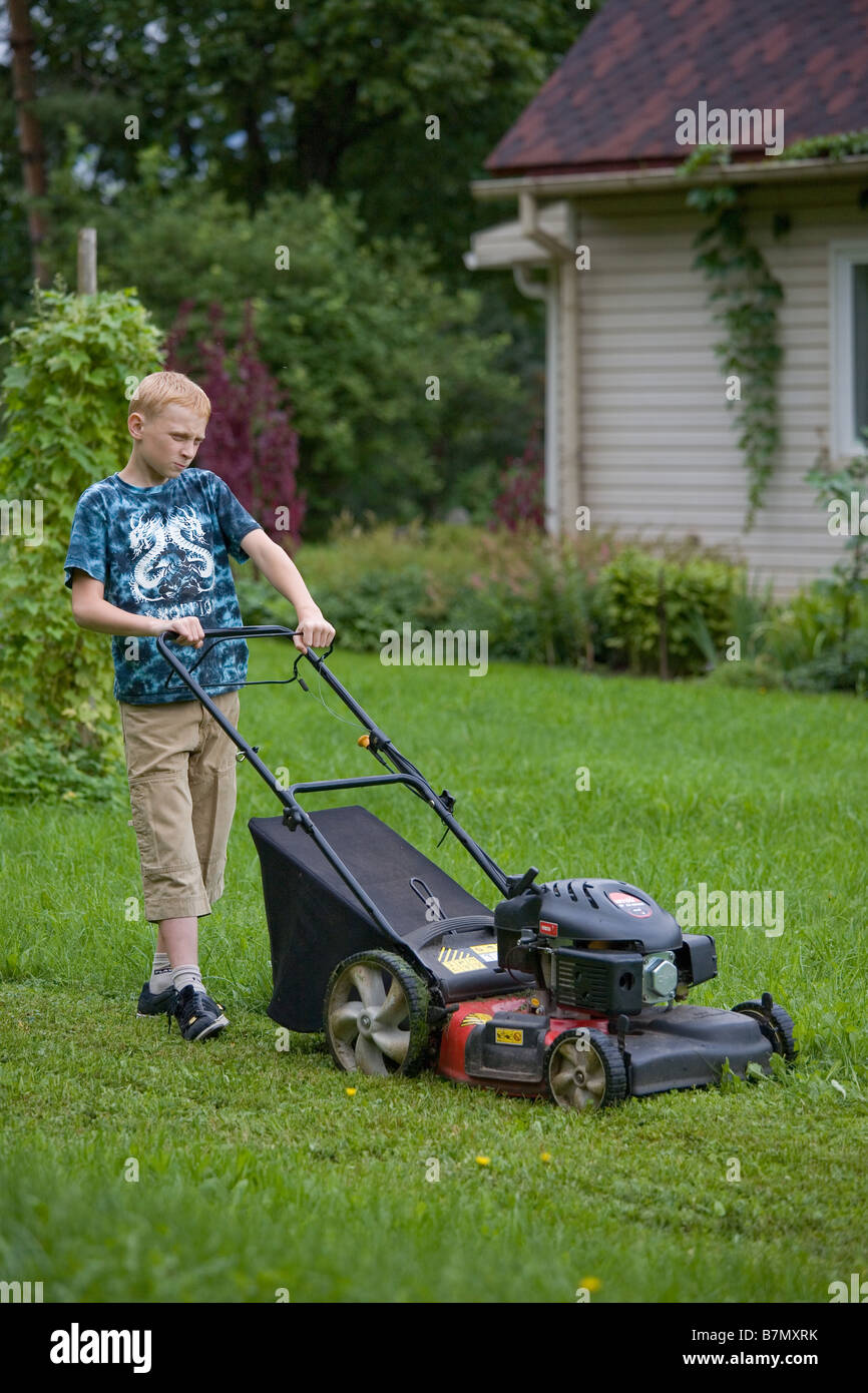 Teenage Boy Pushing Lawn Mower Stock Photo