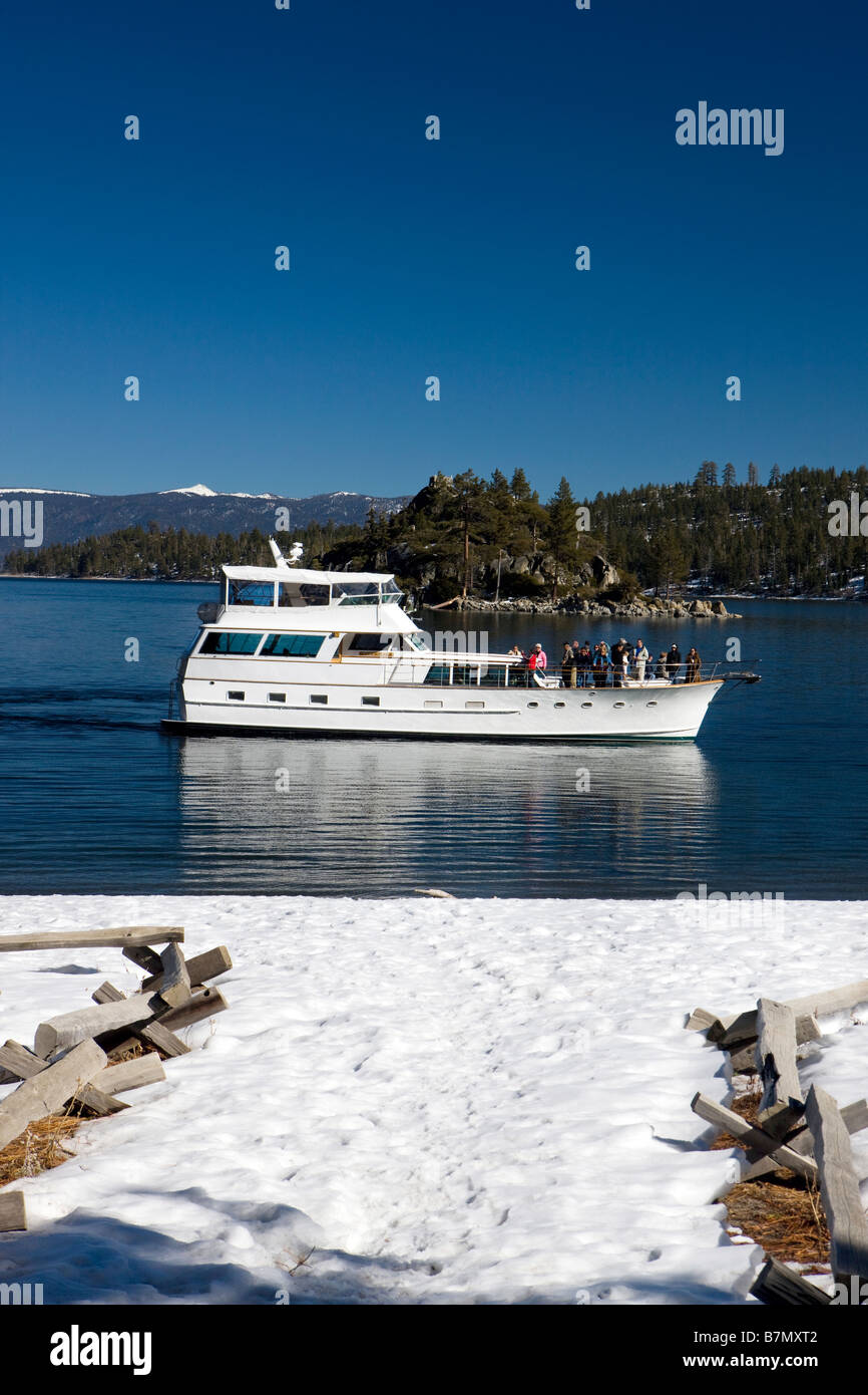 Passengers on a tour boat pass between Fannette Island and Vikingsholm Emerald Bay State Park Lake Tahoe California Stock Photo