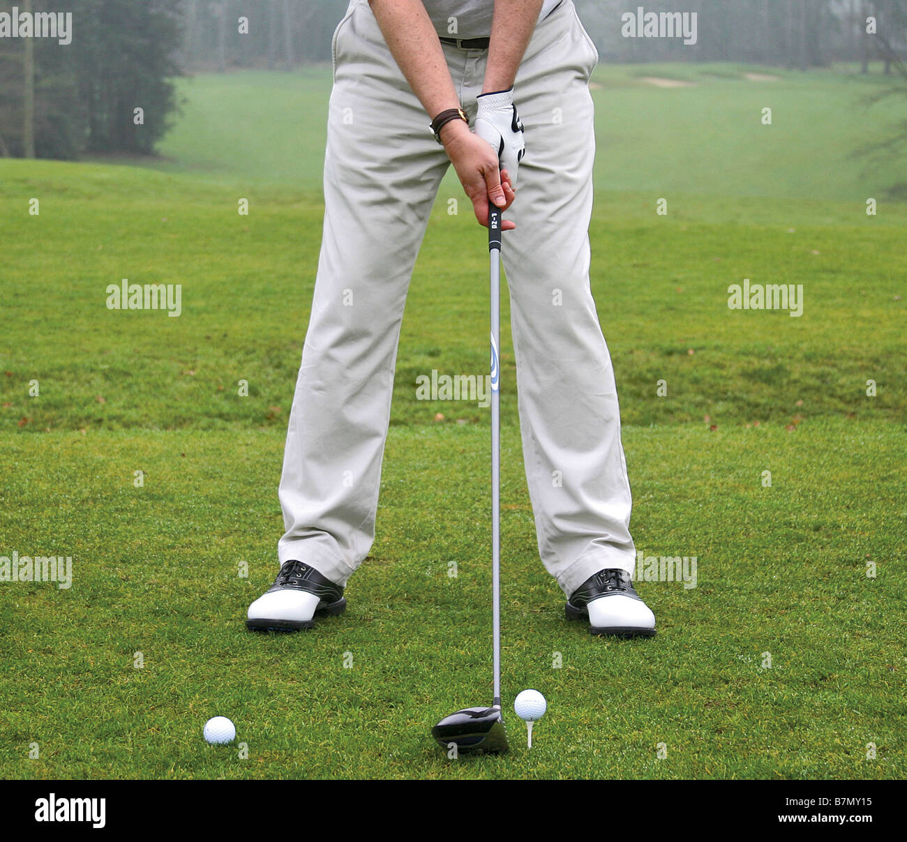 Golfer at address position to golf ball Stock Photo