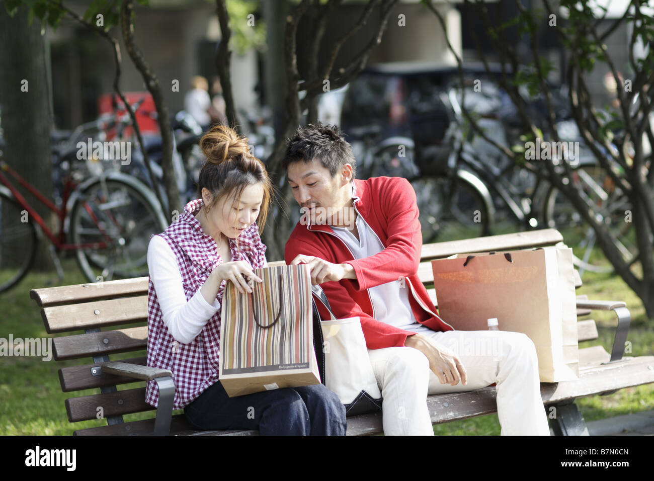Couple Sitting on a Park Bench Stock Photo - Alamy