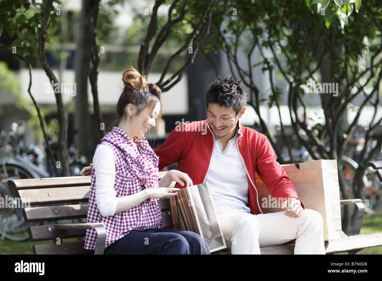 Couple Sitting on a Park Bench Stock Photo - Alamy