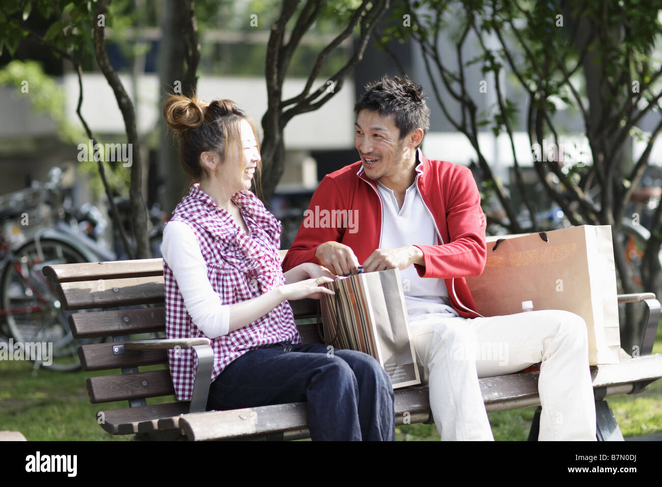 Couple Sitting on a Park Bench Stock Photo - Alamy