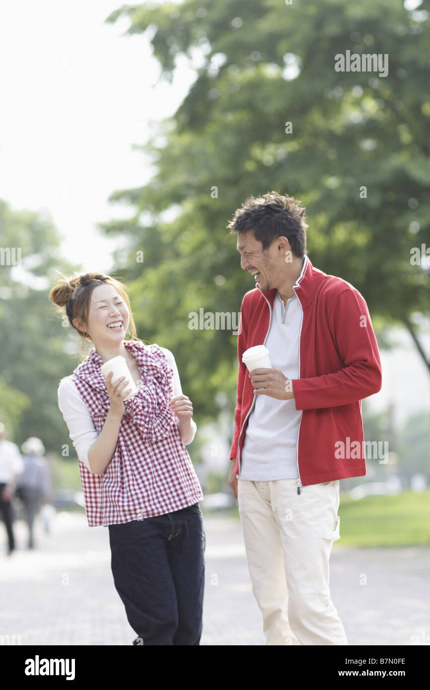 Smiling Couple Holding a Paper Cup Stock Photo - Alamy