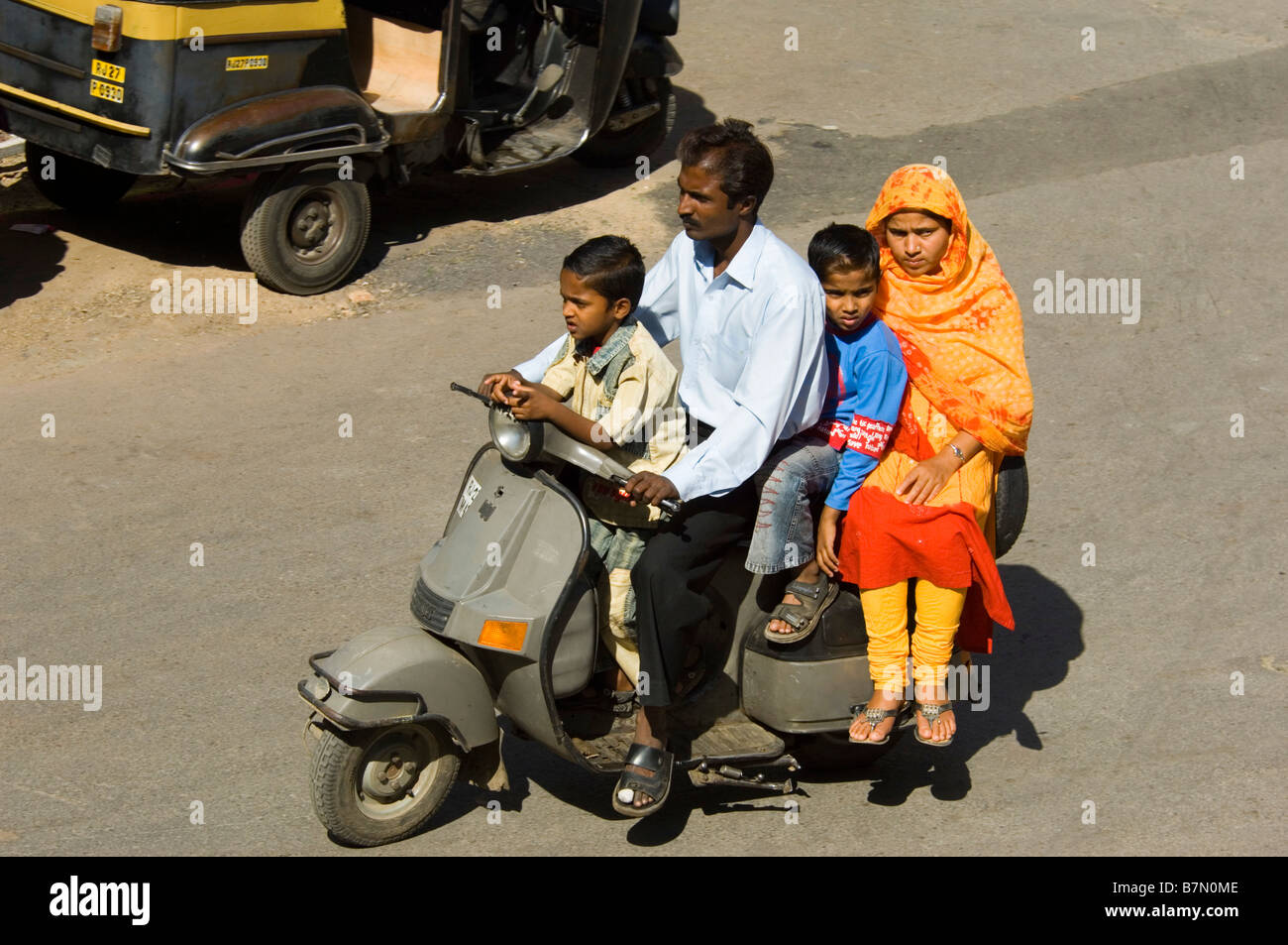 A Rajasthani family of four squashed together on a motor scooter with no crash helmets - a common sight in India. Stock Photo