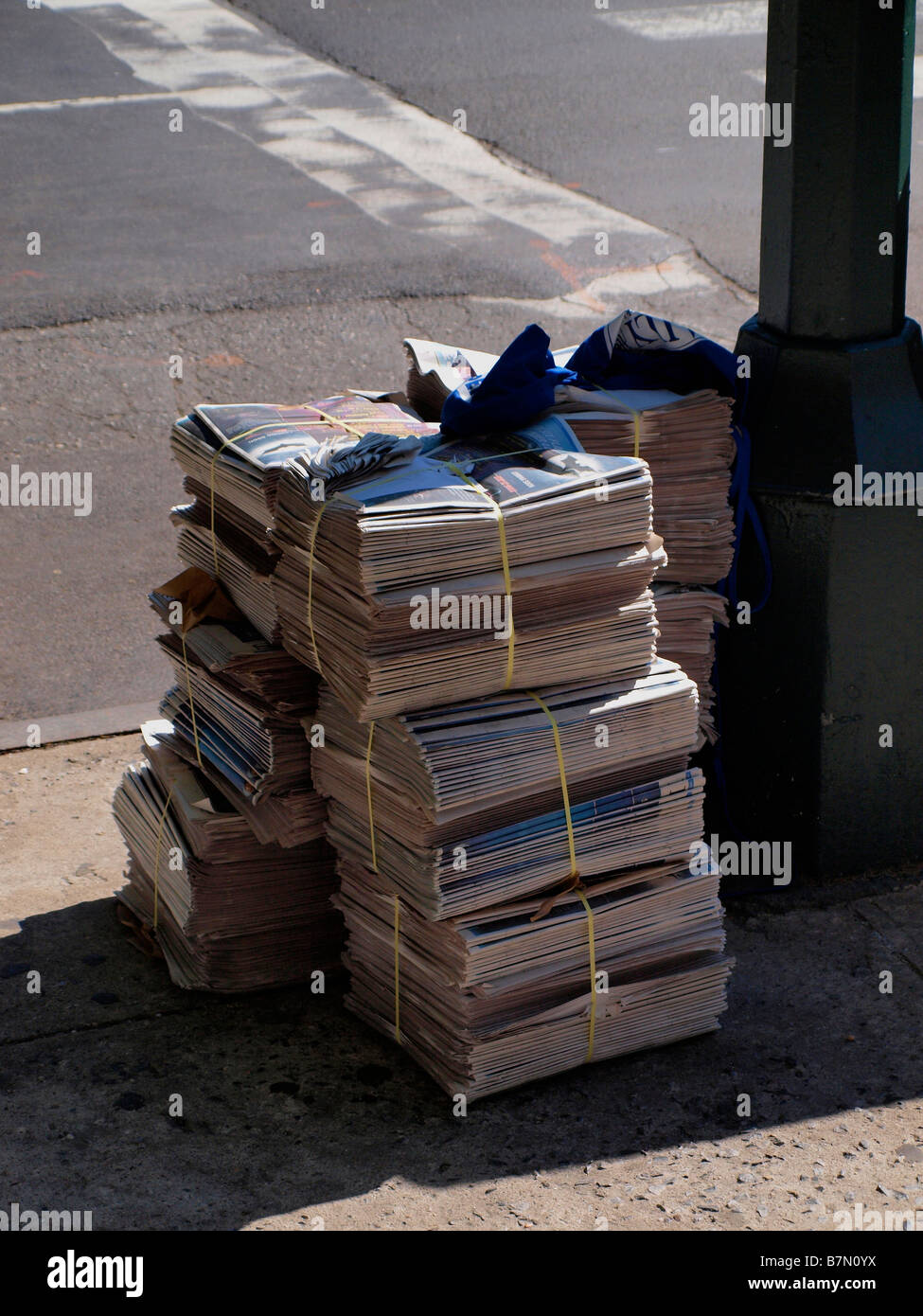 Newspapers stacked for distribution or delivery on a New York City street corner. Stock Photo