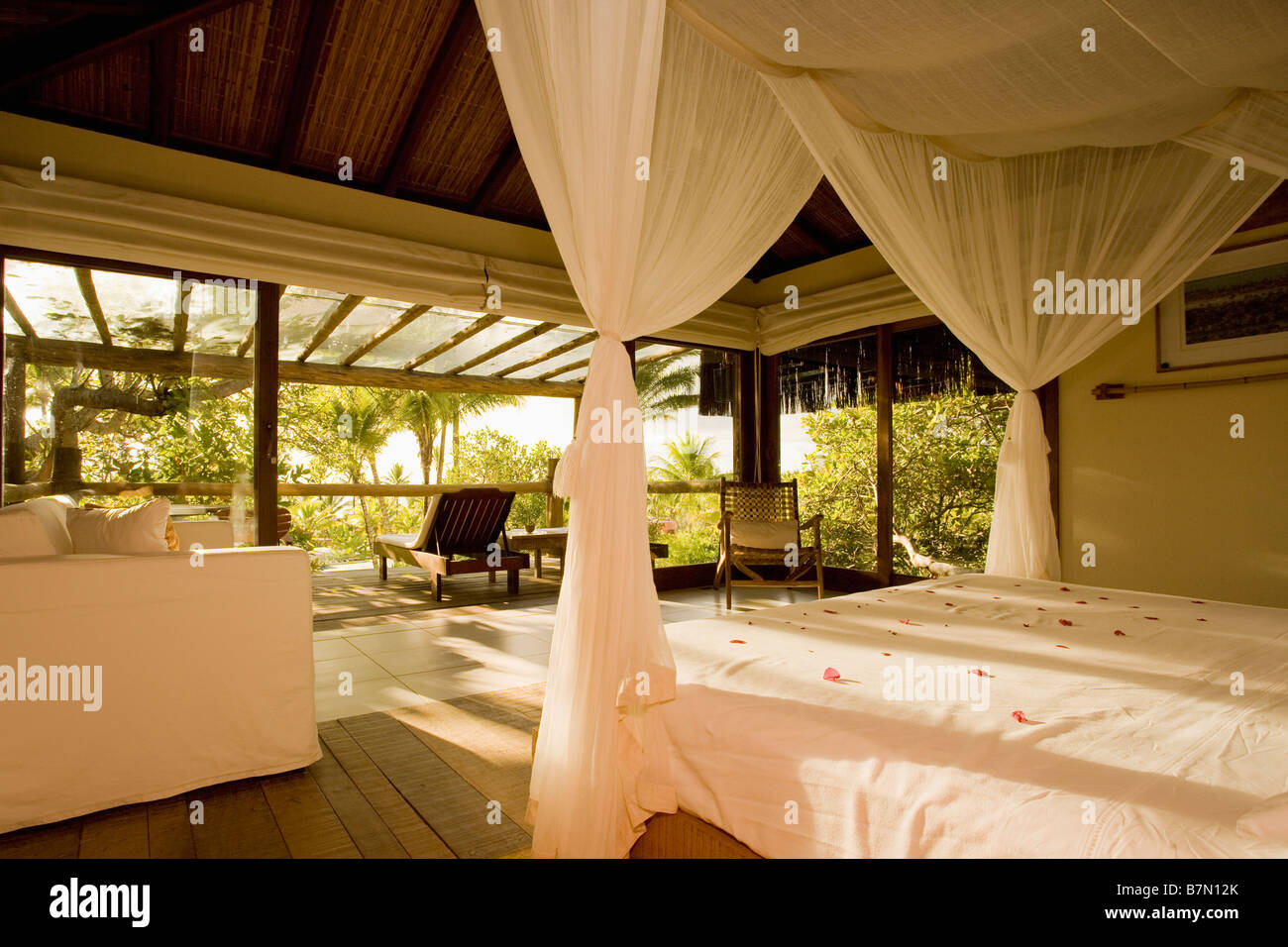 White Voile Drapes And Bedlinen In Modern Openplan Bedroom With
