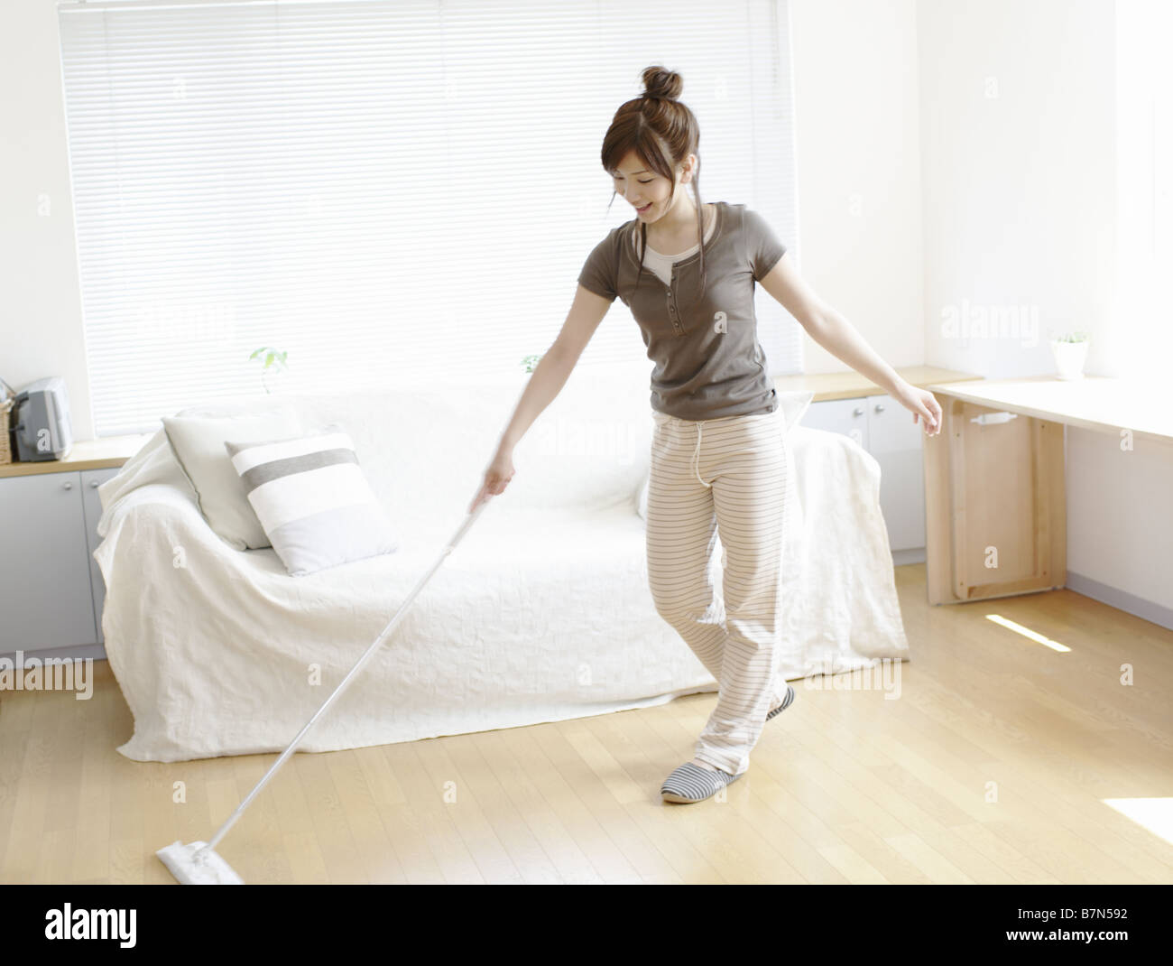 Woman Sweeping Floor in Living Room Stock Photo Alamy