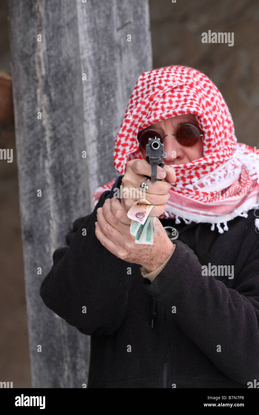Terrorist with a middle eastern headwrap, pointing a gun and holding