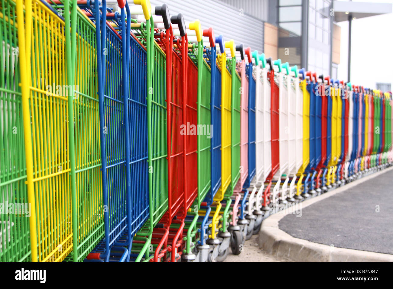 Queue of brightly coloured shopping trolleys Stock Photo