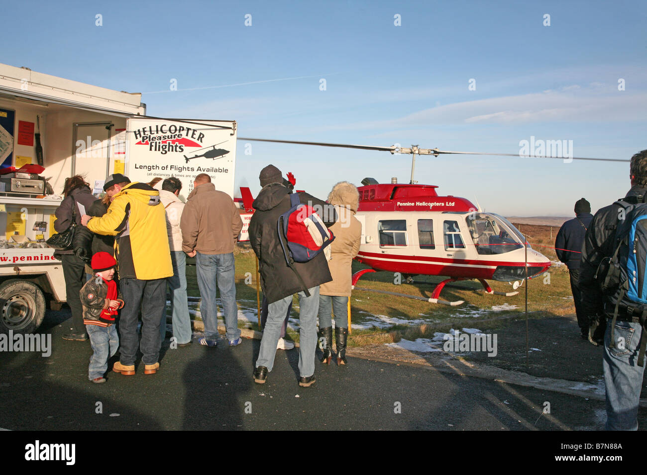 A small helicopter with people waiting to board for a pleasure flight Stock Photo