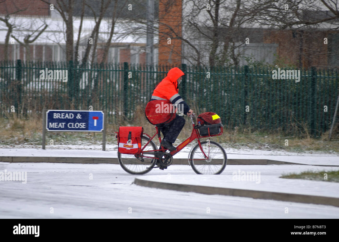 Postman on bike in snow, Warwick, Warwickshire, England, UK Stock Photo