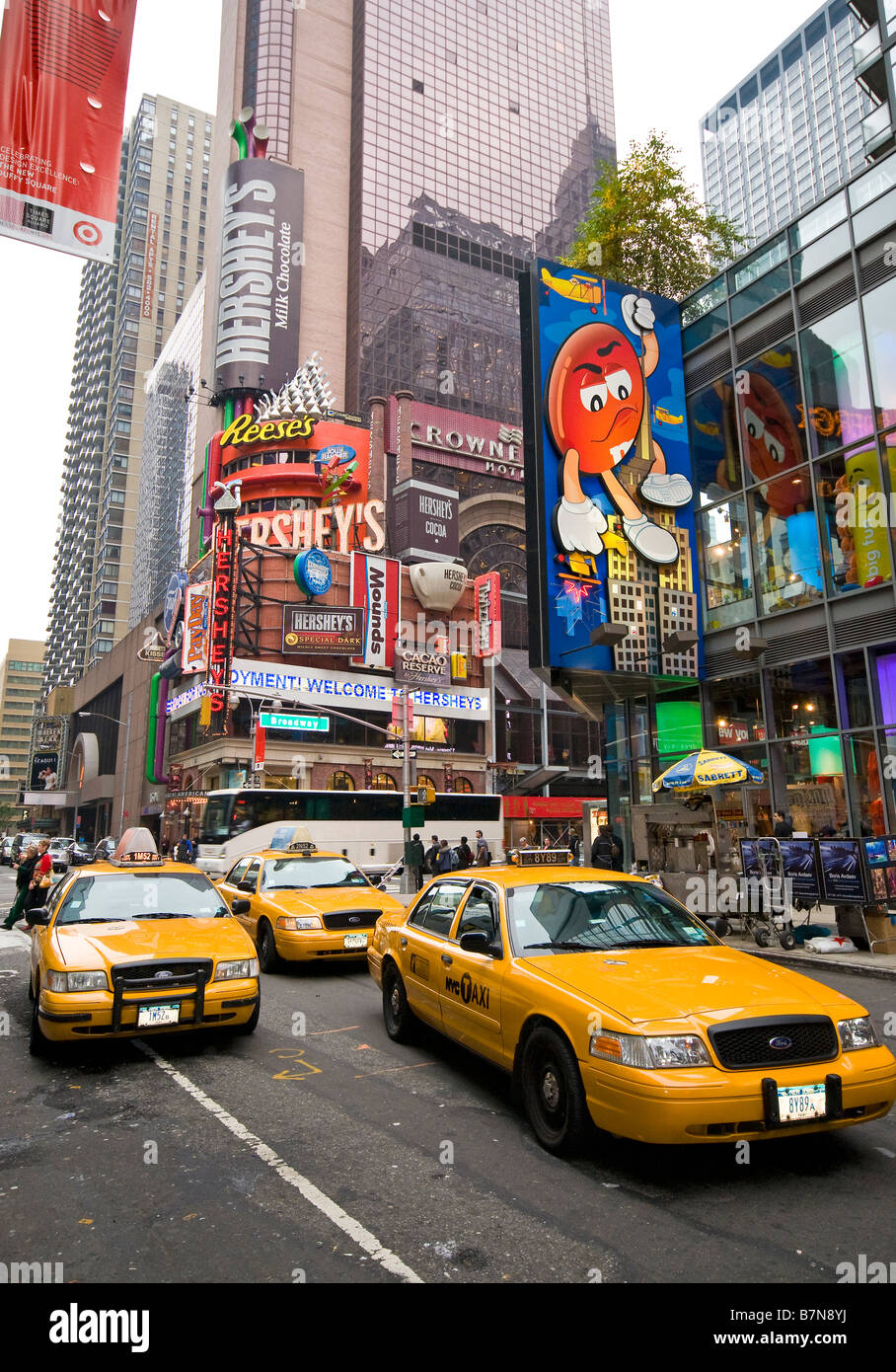 Yellow taxi cabs driving by the M&M's store, New York, USA Stock Photo