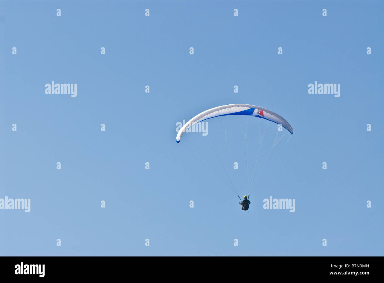 distant view of hang glider in sky Stock Photo