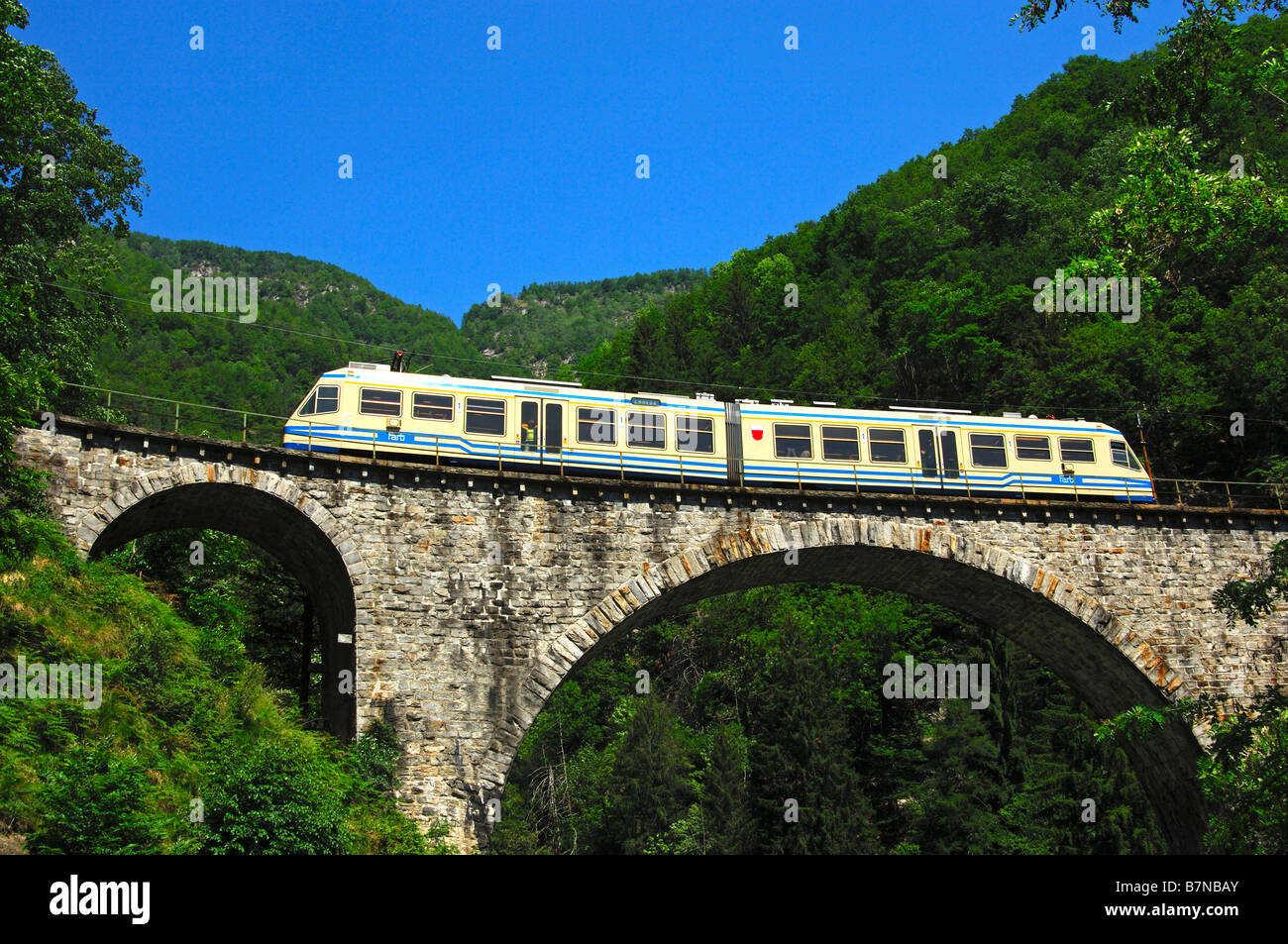 The Centovalli train crosses a viaduct in the Centovalli valley, Ticino, Switzerland Stock Photo