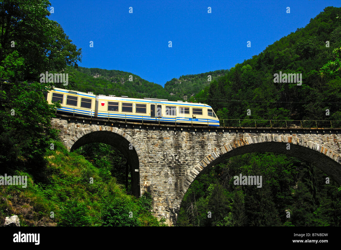 The Centovalli train crosses a viaduct in the Centovalli valley, Ticino, Switzerland Stock Photo