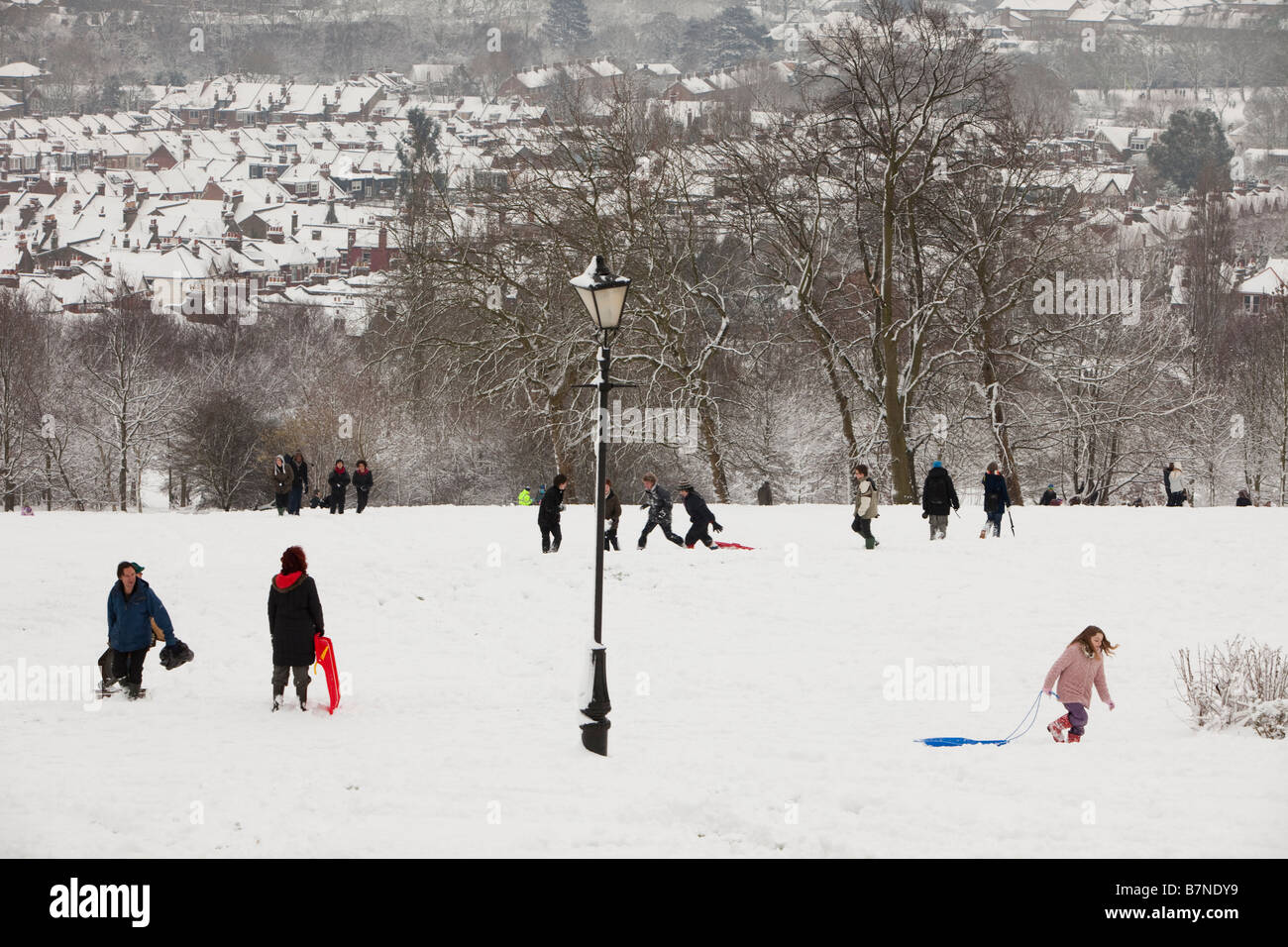 Teenagers play on new snowfalls at Alexandra Pallace north London after schools have closed Stock Photo