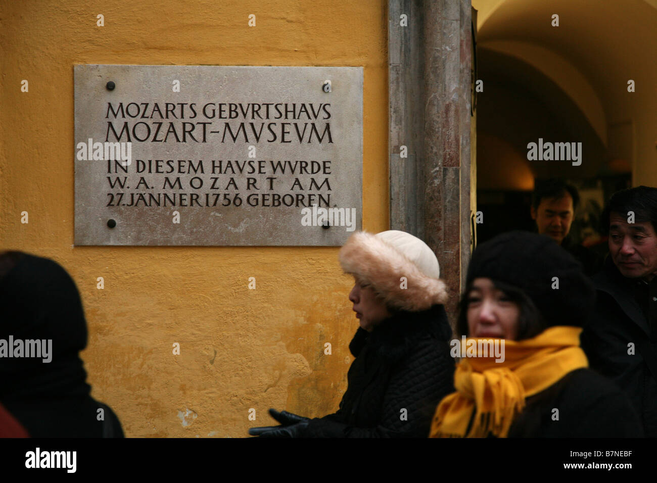 Japanese tourists passes by the house where Wolfgang Amadeus Mozart was born in the historic centre of Salzburg, Austria. Stock Photo