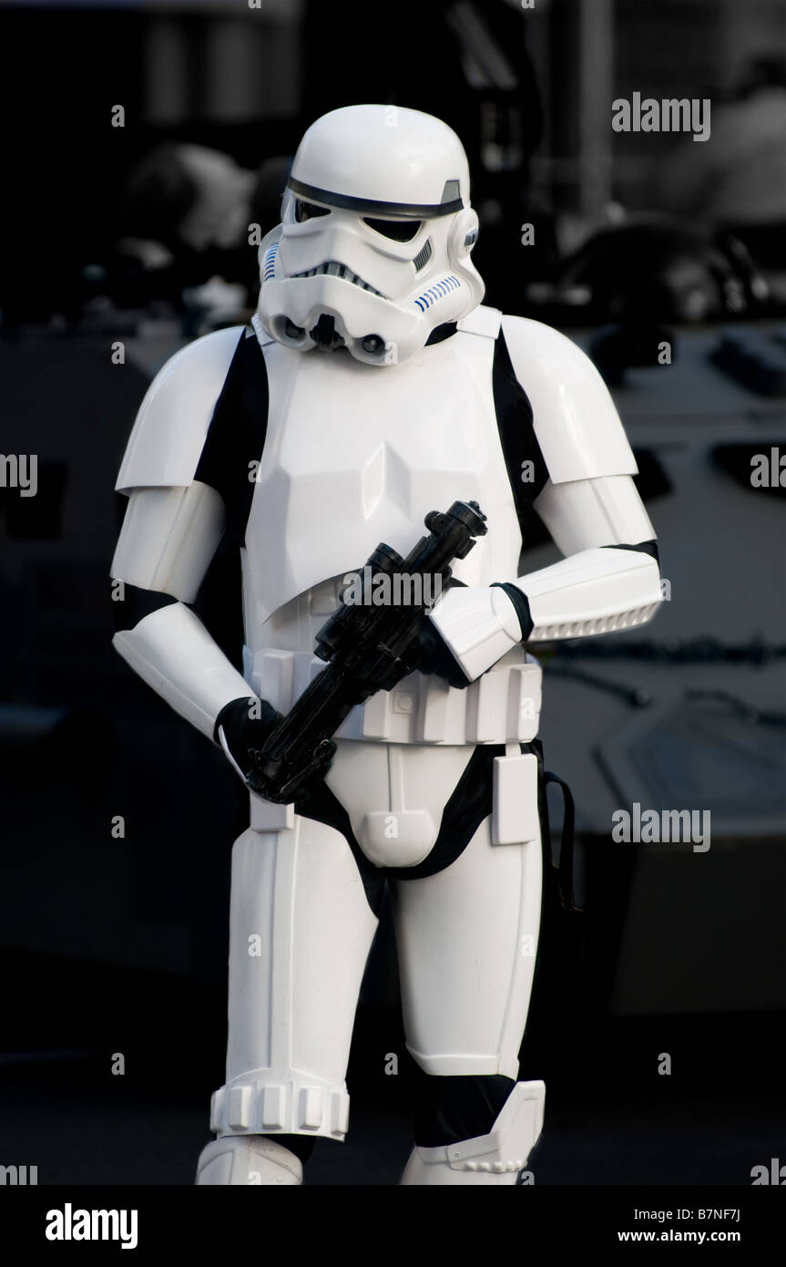 Star Wars Storm Trooper during holiday parade walks with laser gun while standing in front of a Star Wars vehicle. Stock Photo