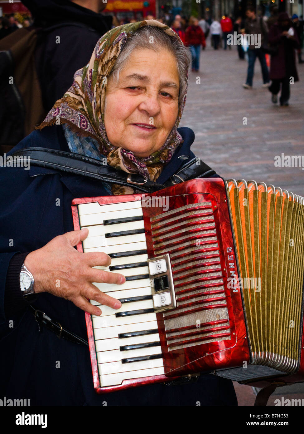 Woman busker playing an accordion for money in Buchanan Street Glasgow
