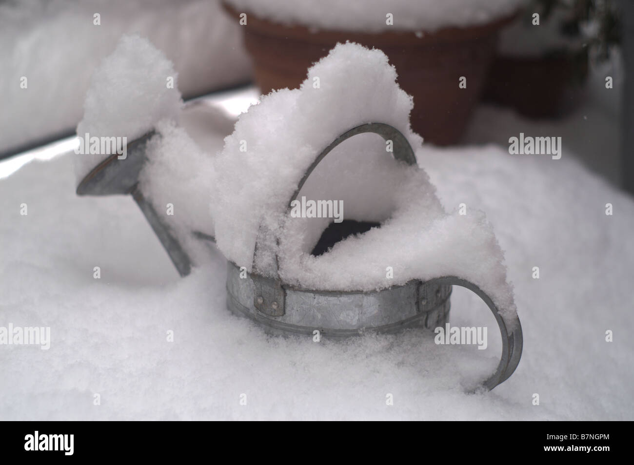 Watering can covered in snow Stock Photo