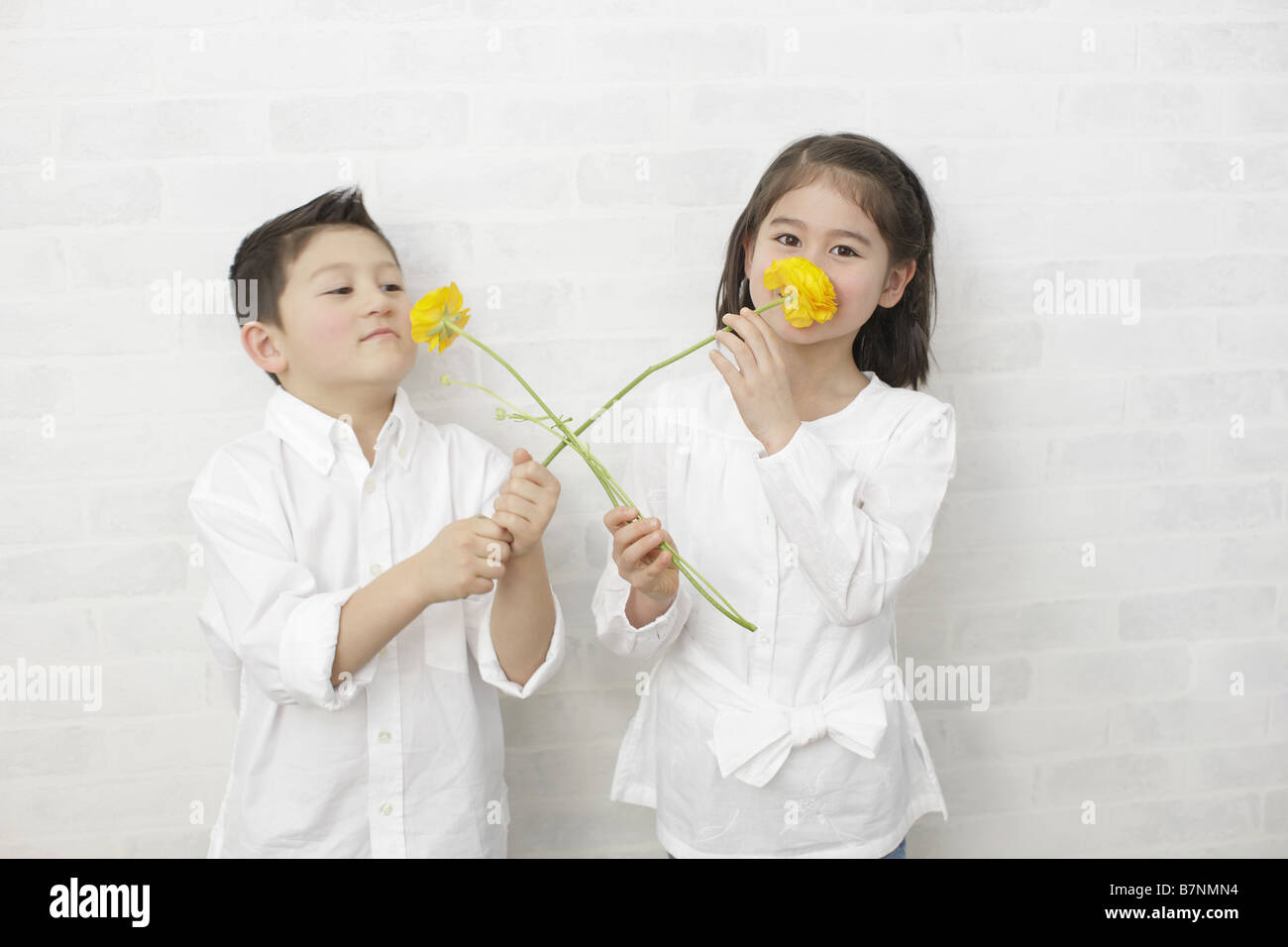 Children smelling flowers Stock Photo