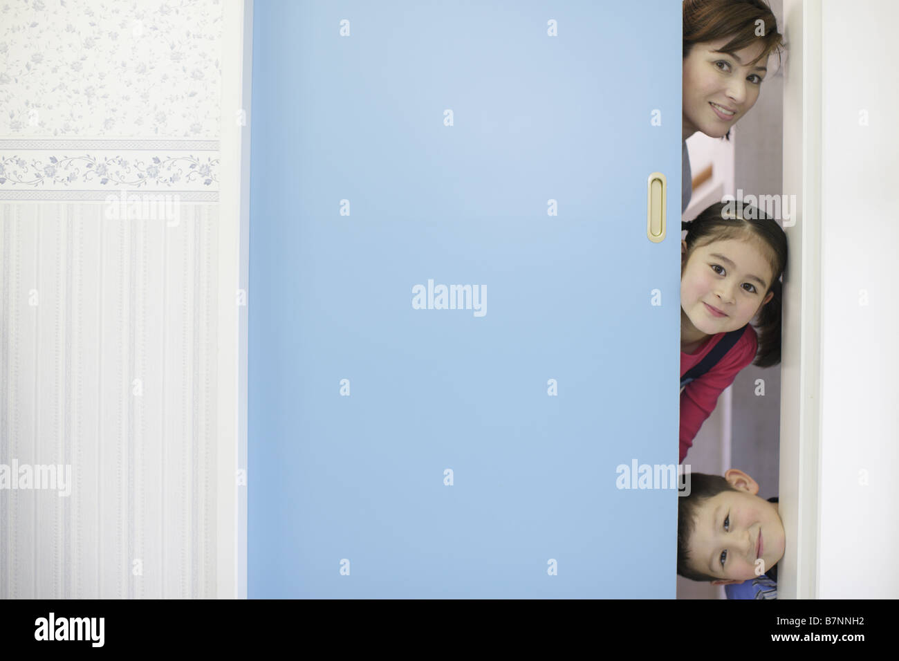 Family hiding behind door Stock Photo Alamy