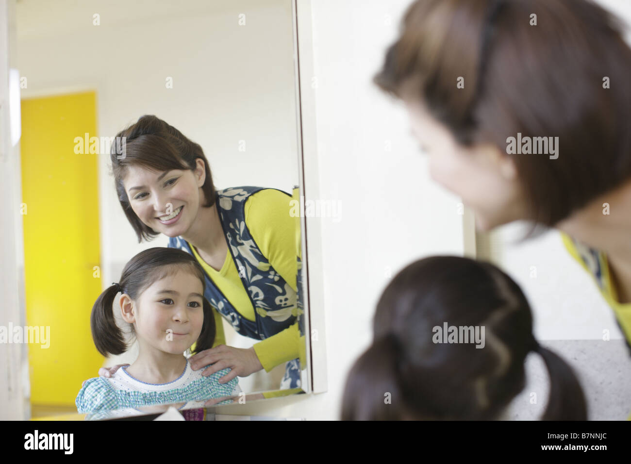 Mother and daughter looking in a mirror Stock Photo